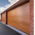 A close-up of two double roller wooden garage doors with a horizontal slat design, set against a brick wall.
